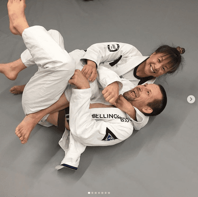 Pans and IBJJF Masters world champion Felicia Oh and BBJJ co-owner and instructor Jeff Shaw laugh while rolling.