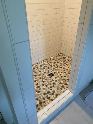 Exterior shot of shower, Paul repaired/replaced several rows of the large subway tile and installed a new shower pan and pebble tile