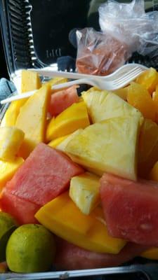 Large container of pineapple, oranges, mango, and watermelon with tahine and salt mix on the side!