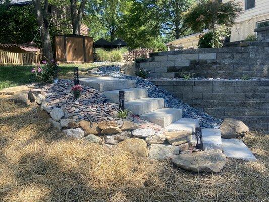 Inviting garden steps flanked by natural stone and vibrant flora leading to a peaceful backyard retreat