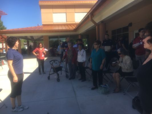 Melody leads a small group in balance exercises at a fall prevention health fair in Albuquerque.