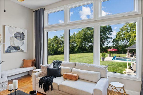 Living room, check out those windows and the amazing view of the pool!