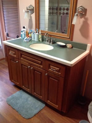 Cherry bathroom cabinet that was ting oiled and has aged to a deeper red patina. The mirror frame is also custom made.