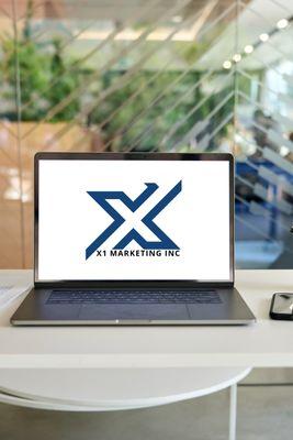 X1 Marketing Inc in Peoria Illinois logo on laptop