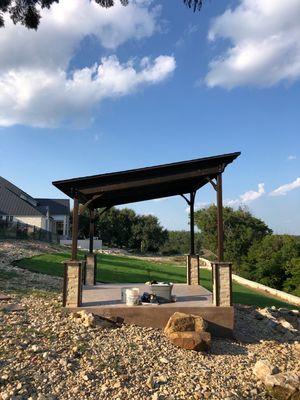 Custom covered pergola with stone wrapped poles with granite tops