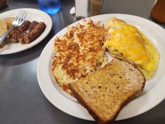 Ham and Cheese omelet,  crispy hash browns, wheat toast and a side of sausage.