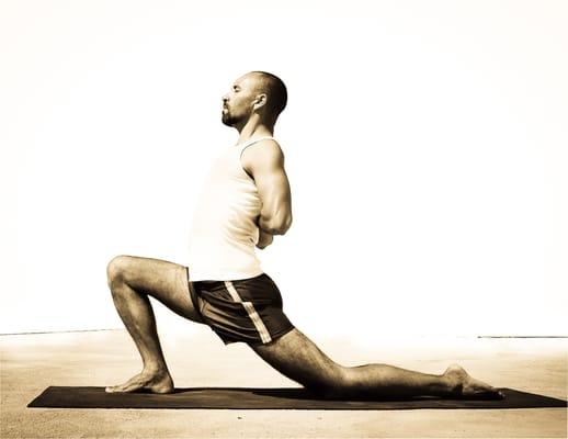 Yoga Teach Carlos da Silva Demonstrating Crescent Pose with Reverse Anjali Mudra in Greece.