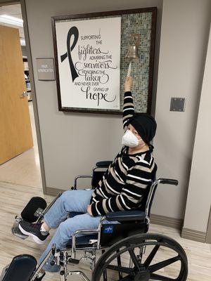 Mom ringing the bell signaling end of her chemo treatments