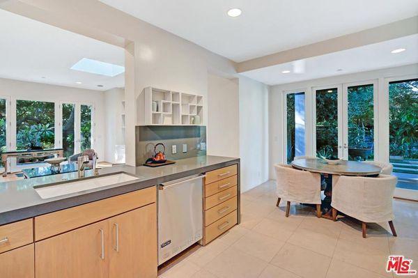 Beautiful modern designed kitchen with modern lighting, beautiful cabinets and tile floor.