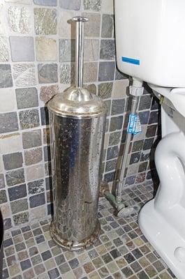 Toilet brush holder rusted from urine splash.