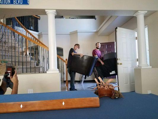 The team moving some chairs while i move a pool table