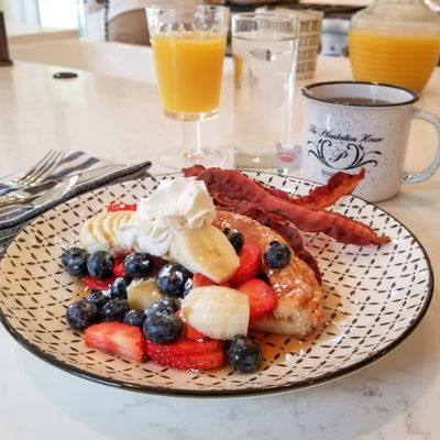 Breakfast: German pancake topped with mixed berries and bacon.