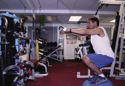 Mike demonstrating proper form of a squatting exercise.