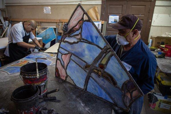 Cementing leaded glass panels.