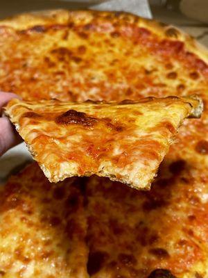 Cheese pizza showing thin crust after a bite