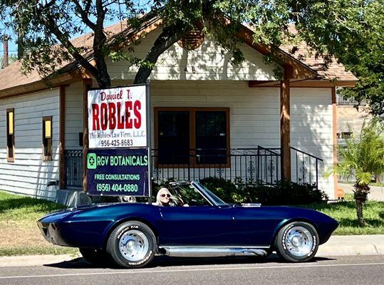 Cruising by my law office with my wife in our old car.