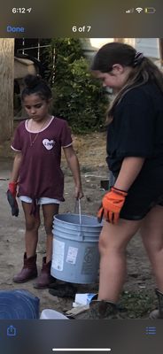 A bunch of kids working picking up trash.