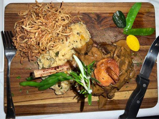 Center cut milk fed veal chop with Porcini mushroom sauce, served with truffle onion straws.