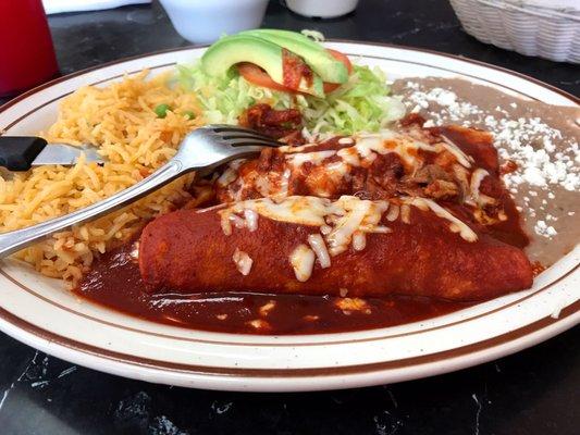 Two enchiladas plate with red sauce, rice, and beans