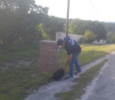 Driver repairing mailbox damage with two rocks as hammer