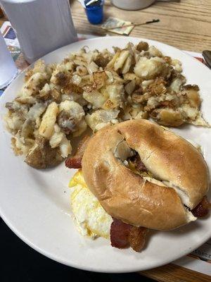 Breakfast sandwich and grilled potatoes with onions