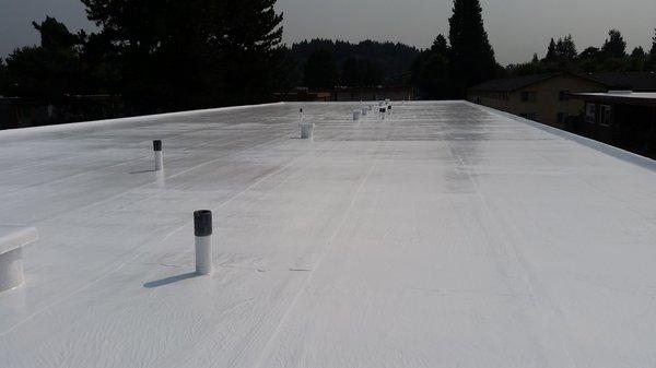 Silicone roof restoration on smooth torch down deck.  30 mil minimum thickness.  New 26ga perimeter flashing.