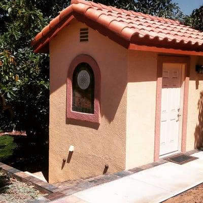 This cute shed stores our gardening tools. It matches our house pefecty. Stairs go down to the garden.