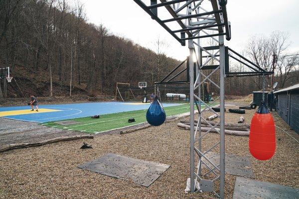 Outdoor fitness area with full basketball court, batting cage and obstacle course/monkey bars