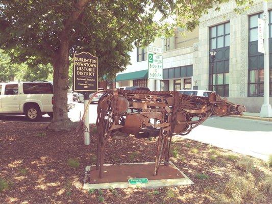 A cow made out of scrap metal