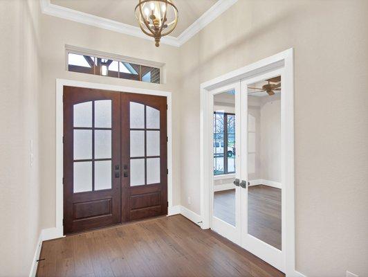 Craftsman style double front doors welcome you into tall ceilings at foyer