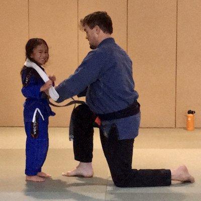 My daughter being promoted to Grey Belt after 9 months of hard work and training.