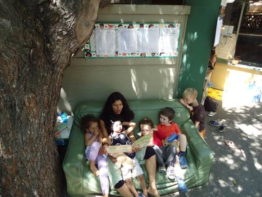 A book is read by a teacher to children in Little Nursery.