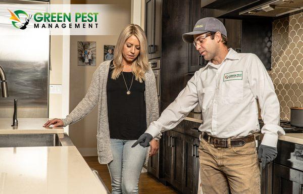 Green Pest Management pest control technician talking with a customer.