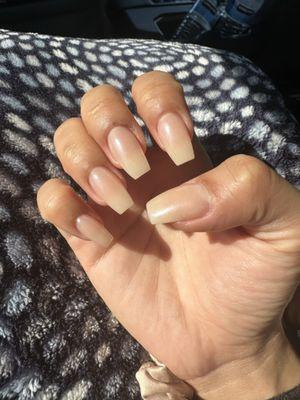 Right hand of the manicure in the sunlight. This is full set dip powder with a nude powder color and chrome on top