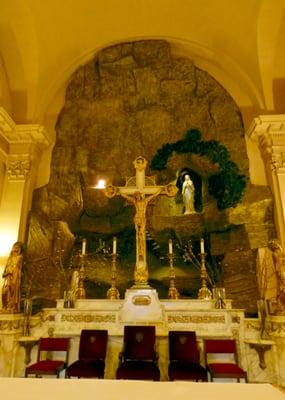 Behind the altar is replicate of the Grotto where Our Lady appeared to St. Bernadette in France in 1858.