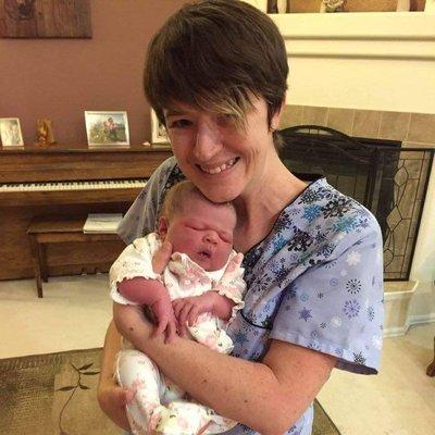 Tiffany, midwife, snuggling a sweet newborn baby girl after her fast, safe, healthy home birth outside Colorado Springs.