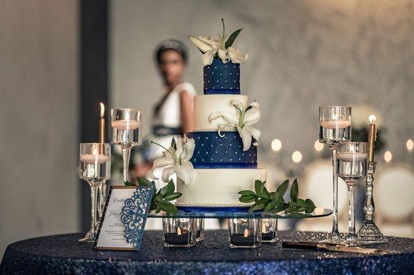 Beautifully done wedding reception with 4 tier Navy blue and white wedding cake with lilies.