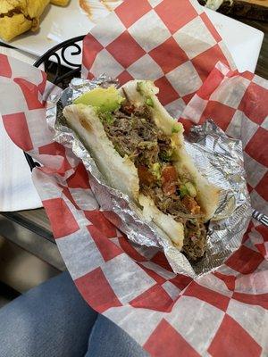 Arepa rellena con Carne Desmechada, avocado, tomato, and cheese