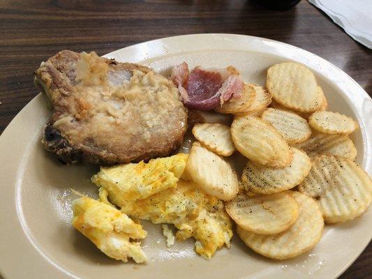 Fried pork chop, country ham, scrambled eggs and home fries.