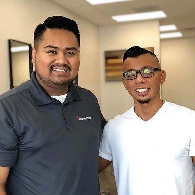 John Khut (right) with a customer after cutting his hair (left).