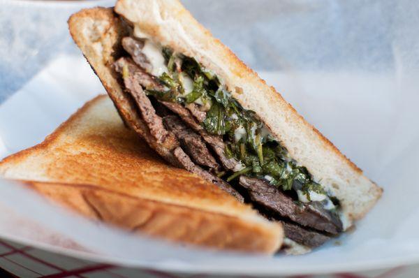 The Chimmi Hendrix: A sliced steak sandwich with roasted red onions, cheese, garlic aioli, and chimichurri sauce- unbelievably good!