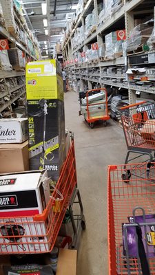 Filled carts splattered throughout the store blocking the aisle.