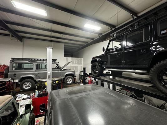 Full shop with 4 British Land Rover Defenders in for routine service and restoration.