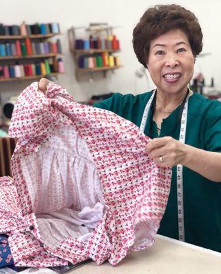 Esther's Alterations' lead seamstress picks up my dress for a hem.