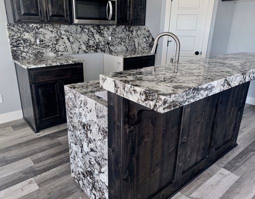 Granite kitchen with full backsplash and waterfall edge island.