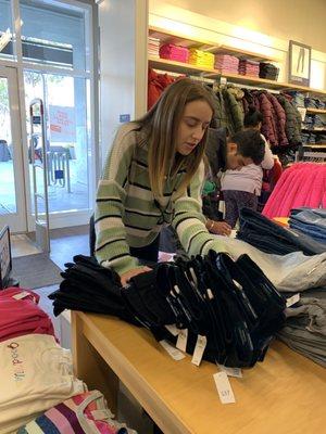 Employee (Ashley) helping me find a size I want in jeans.