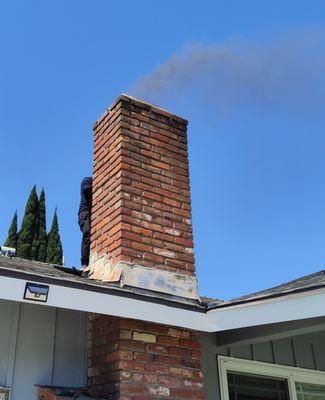 That soot is being blown UP the chimney by a leaf blower.  One guy spent 20 minutes blowing soot all over my neighborhood.