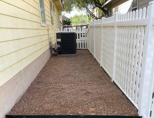 Clean and level pea gravel in unused area on side of house