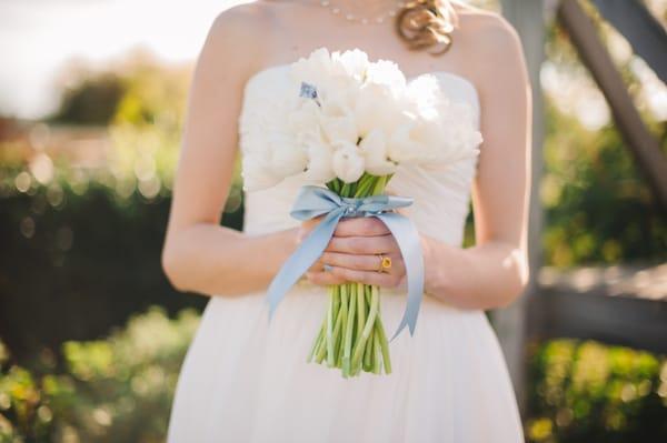 The gorgeous bouquet by Bethany. White tulips with a light blue satin ribbon.