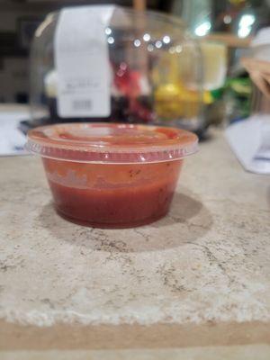 Barely half way filled sauce container for 6 breadsticks